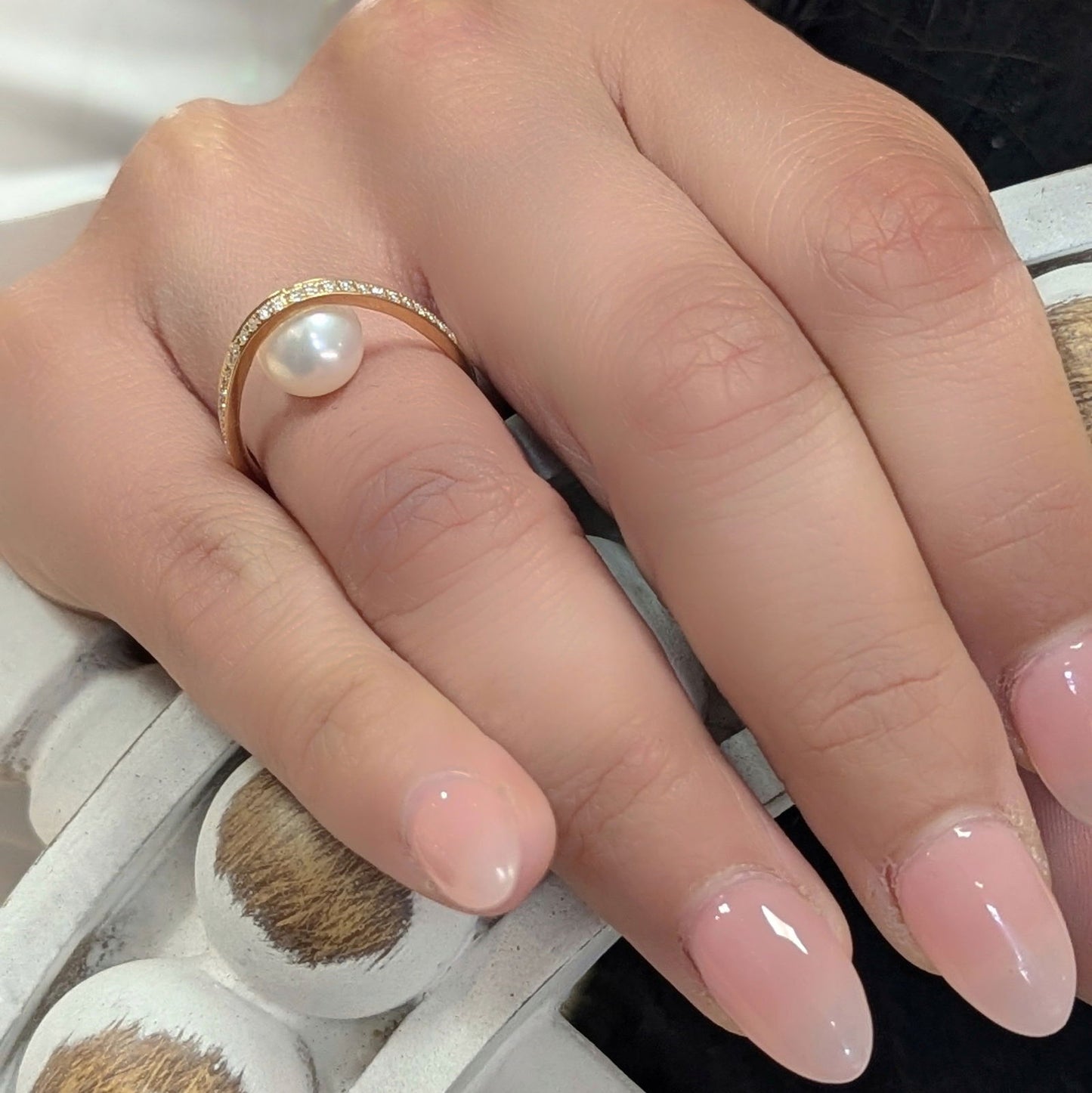 Photo of "Pearl Arch" Ring in a decorative scene, designed by , available at Plumb Gold & Plumb Silver