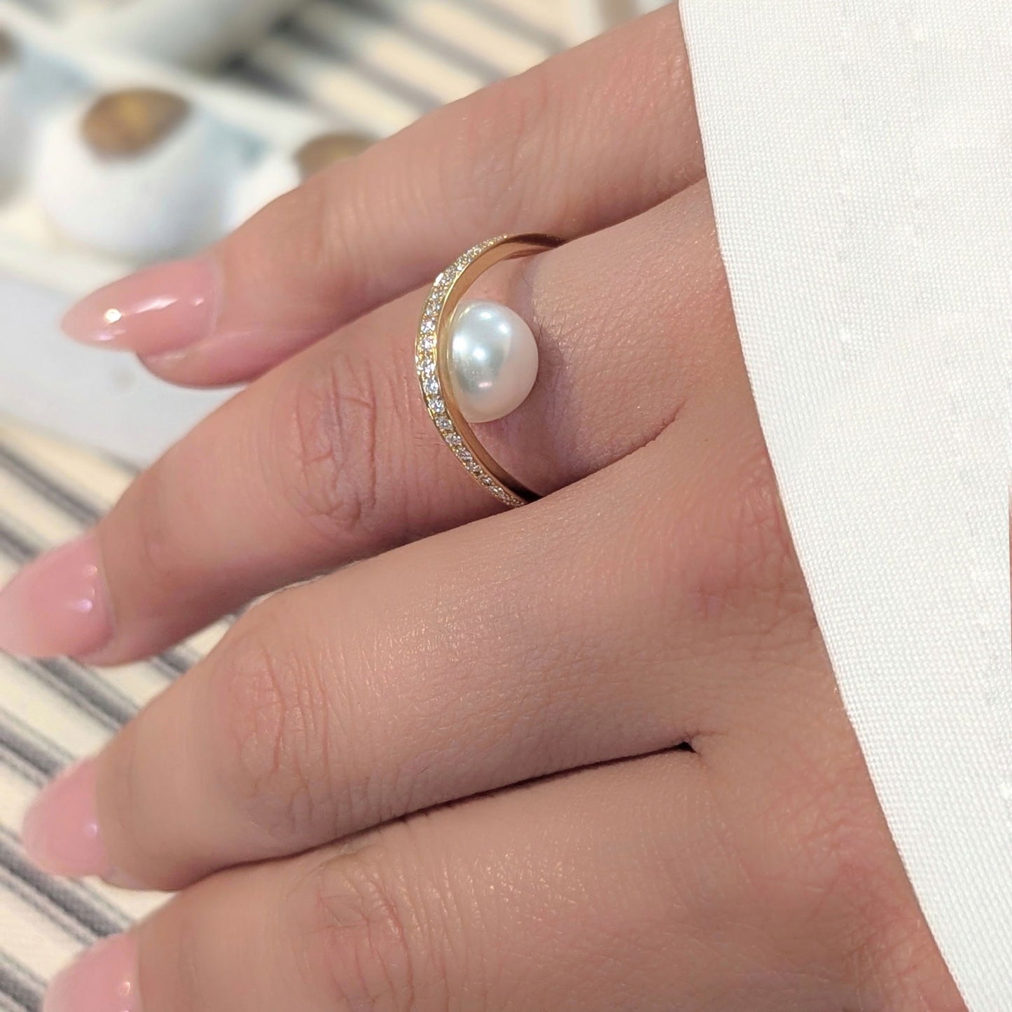 Photo of "Pearl Arch" Ring in a decorative scene, designed by , available at Plumb Gold & Plumb Silver