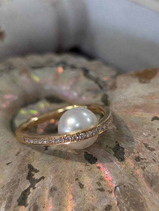 Photo of "Pearl Arch" Ring in a decorative scene, designed by , available at Plumb Gold & Plumb Silver