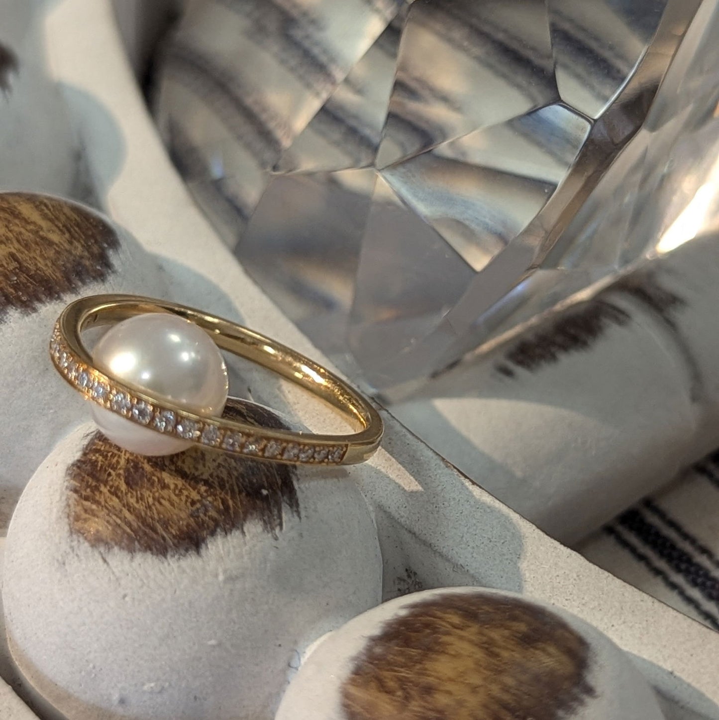 Photo of "Pearl Arch" Ring in a decorative scene, designed by , available at Plumb Gold & Plumb Silver