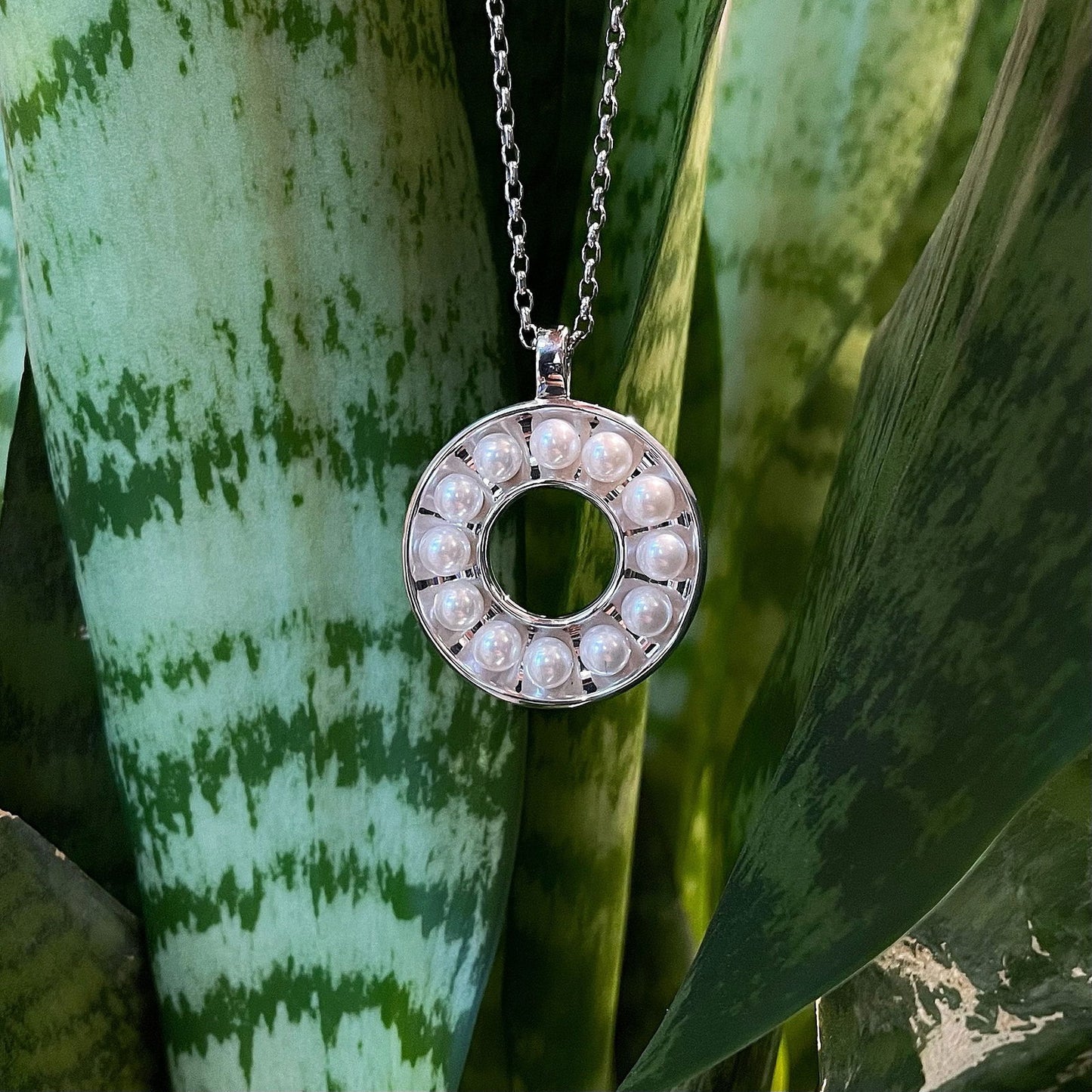 Photo of Pearl Circle Pendant in a decorative scene, designed by , available at Plumb Gold & Plumb Silver
