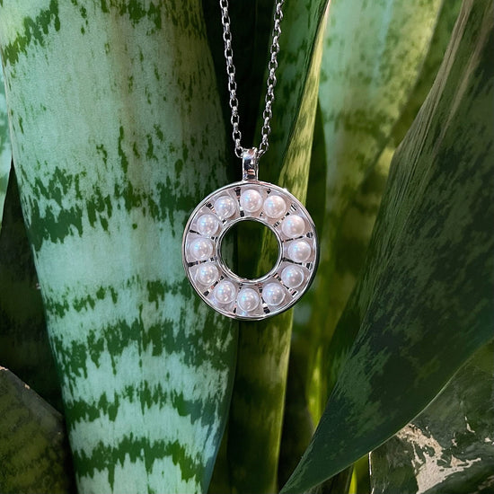 Photo of Pearl Circle Pendant in a decorative scene, designed by , available at Plumb Gold & Plumb Silver