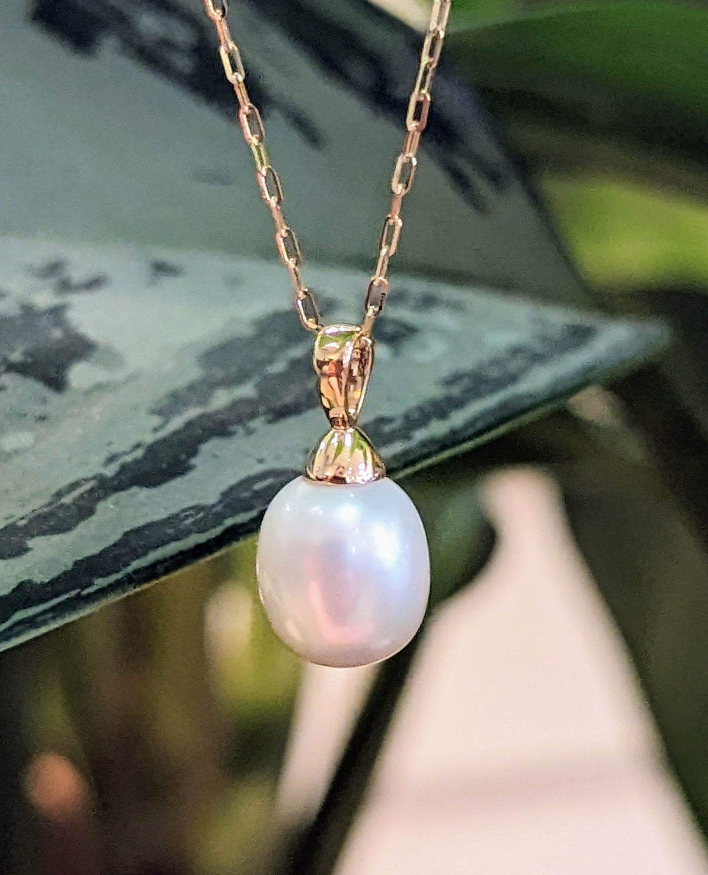 Photo of Pearl Drop Necklace in a decorative scene, designed by , available at Plumb Gold & Plumb Silver