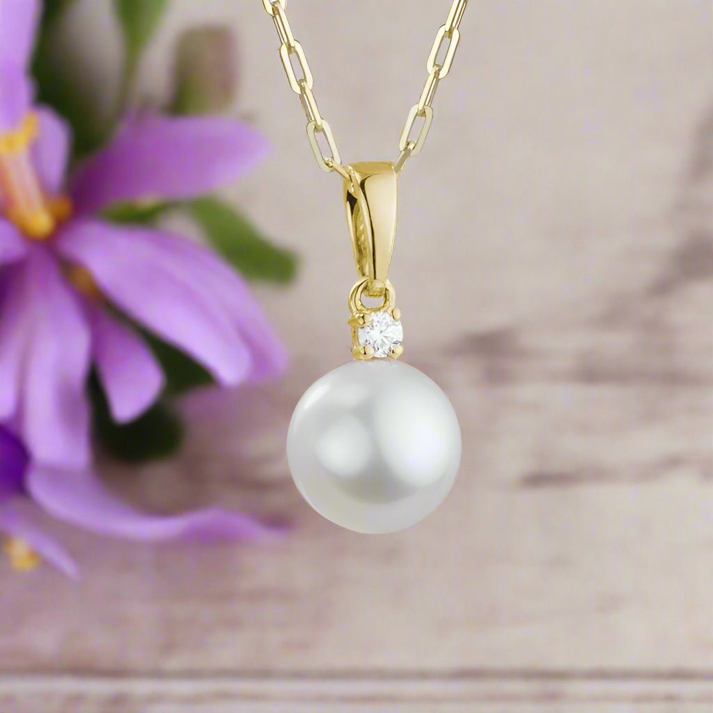 Photo of Pearl Solitaire Necklace in a decorative scene, designed by , available at Plumb Gold & Plumb Silver