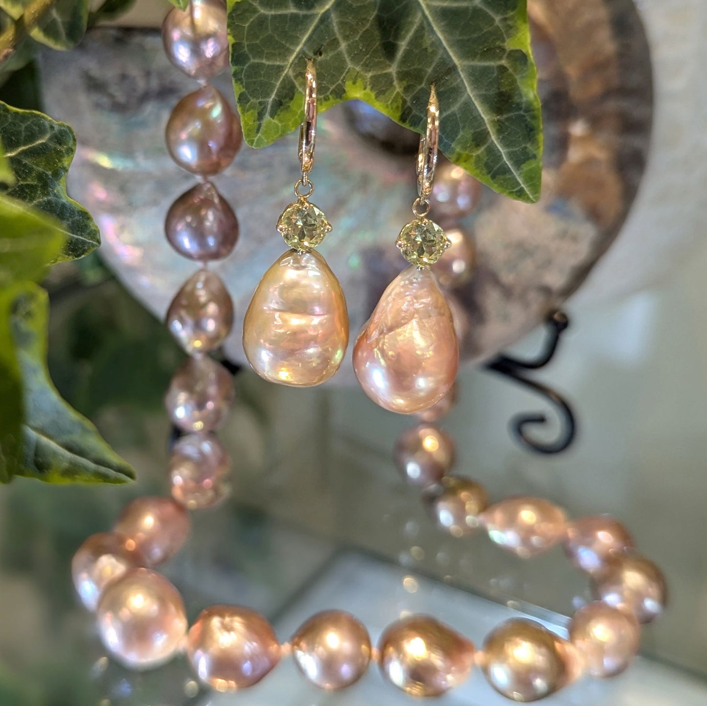 Photo of Pearl and Chrysoberyl Earrings in a decorative scene, designed by , available at Plumb Gold & Plumb Silver