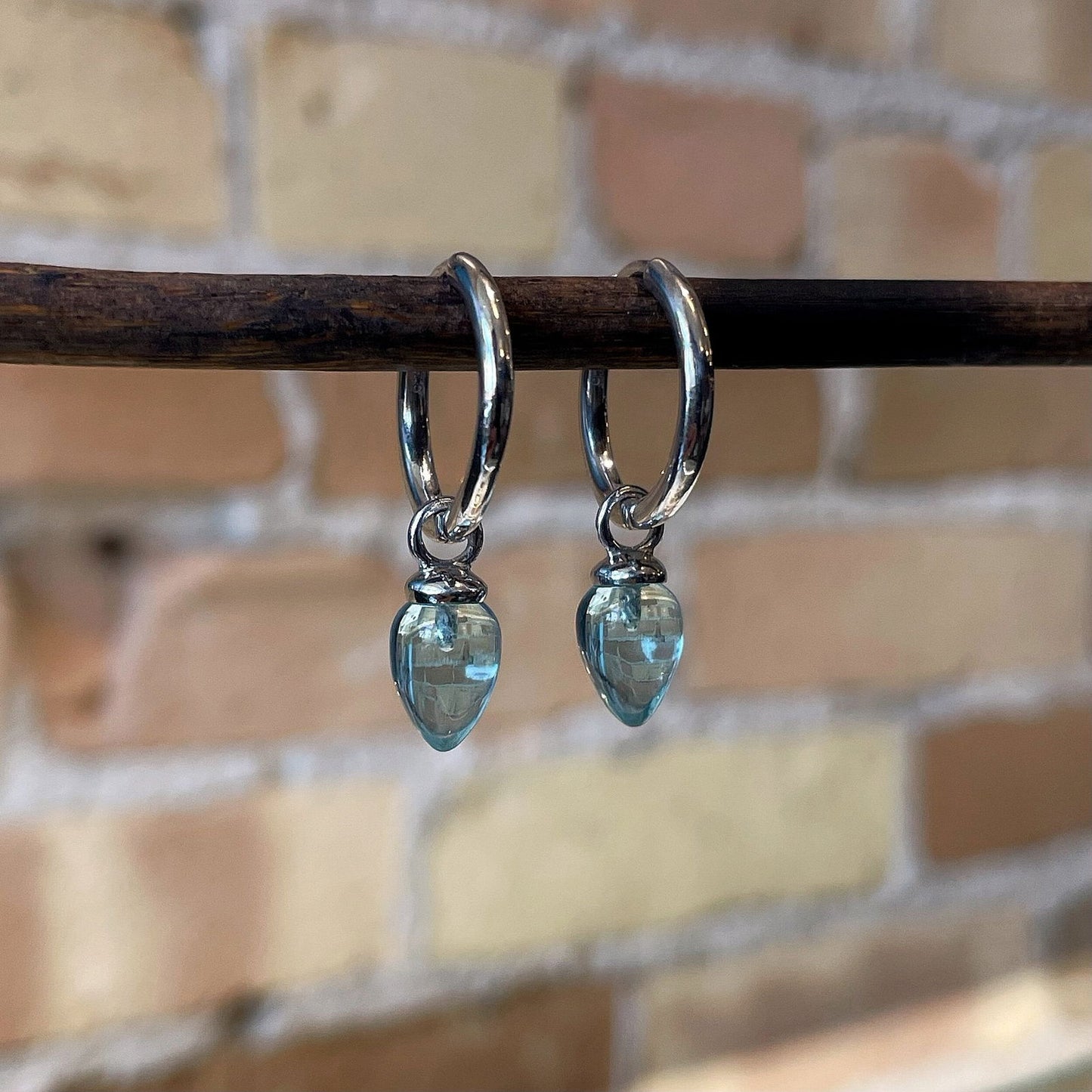 Photo of “Pendulum” Blue Topaz Dangles in a decorative scene, designed by , available at Plumb Gold & Plumb Silver