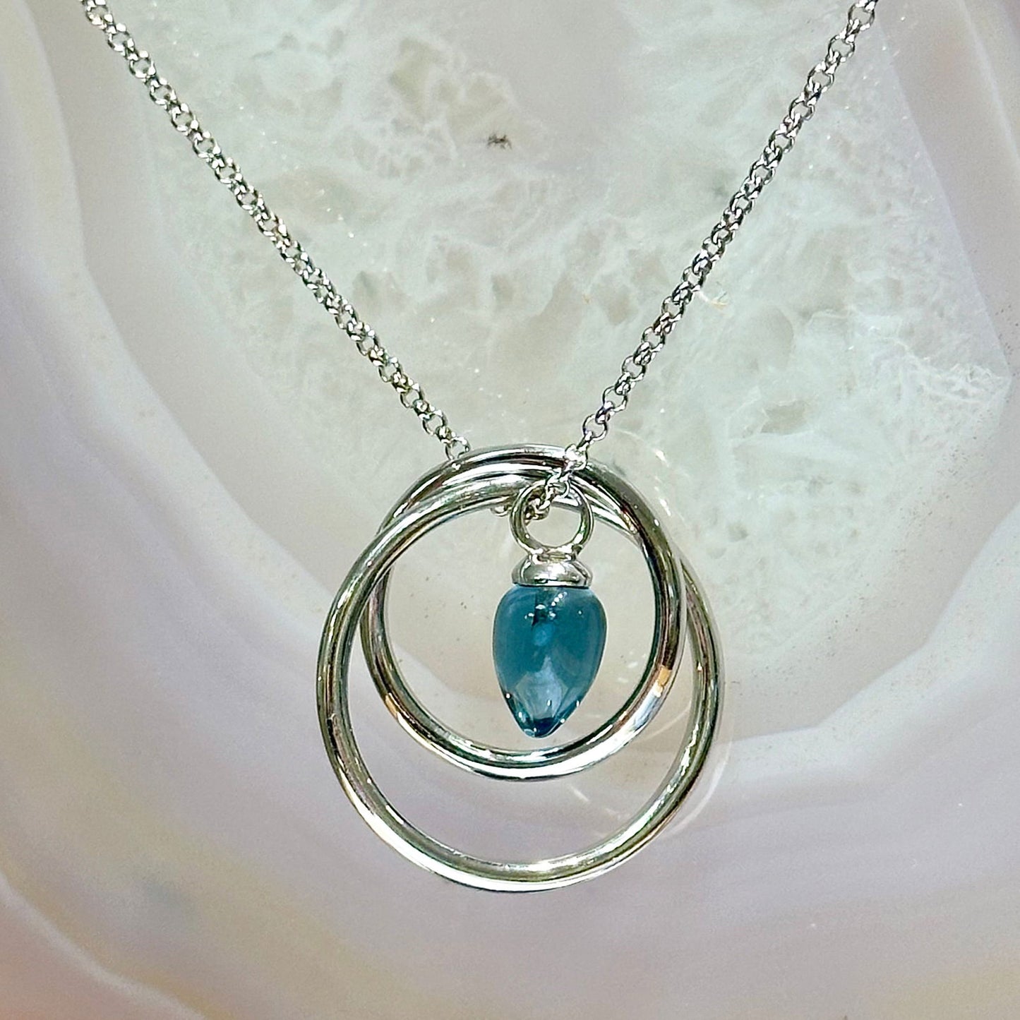 Photo of Pendulum Necklace in a decorative scene, designed by -, available at Plumb Gold & Plumb Silver