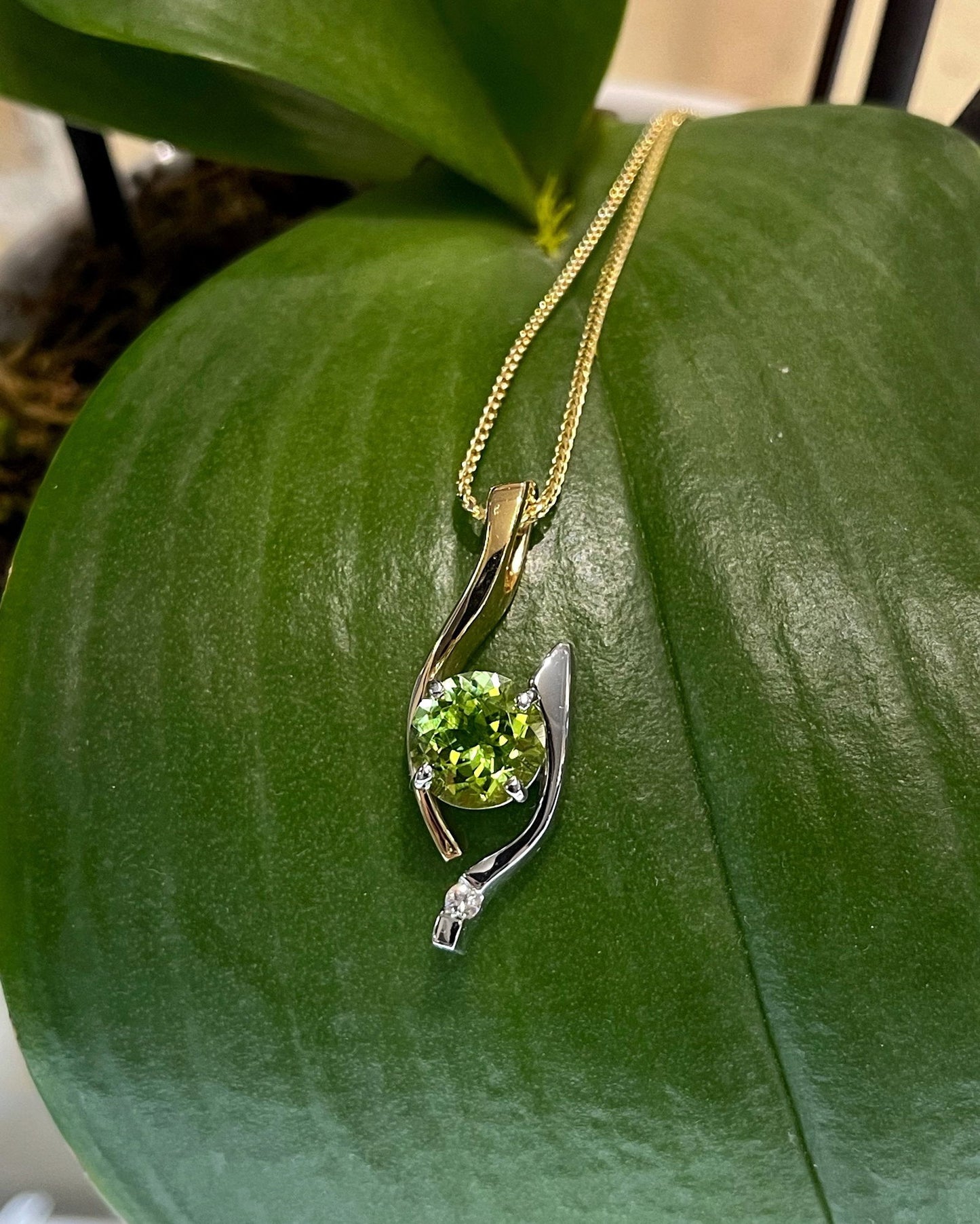 Photo of Peridot Pendant in a decorative scene, designed by , available at Plumb Gold & Plumb Silver