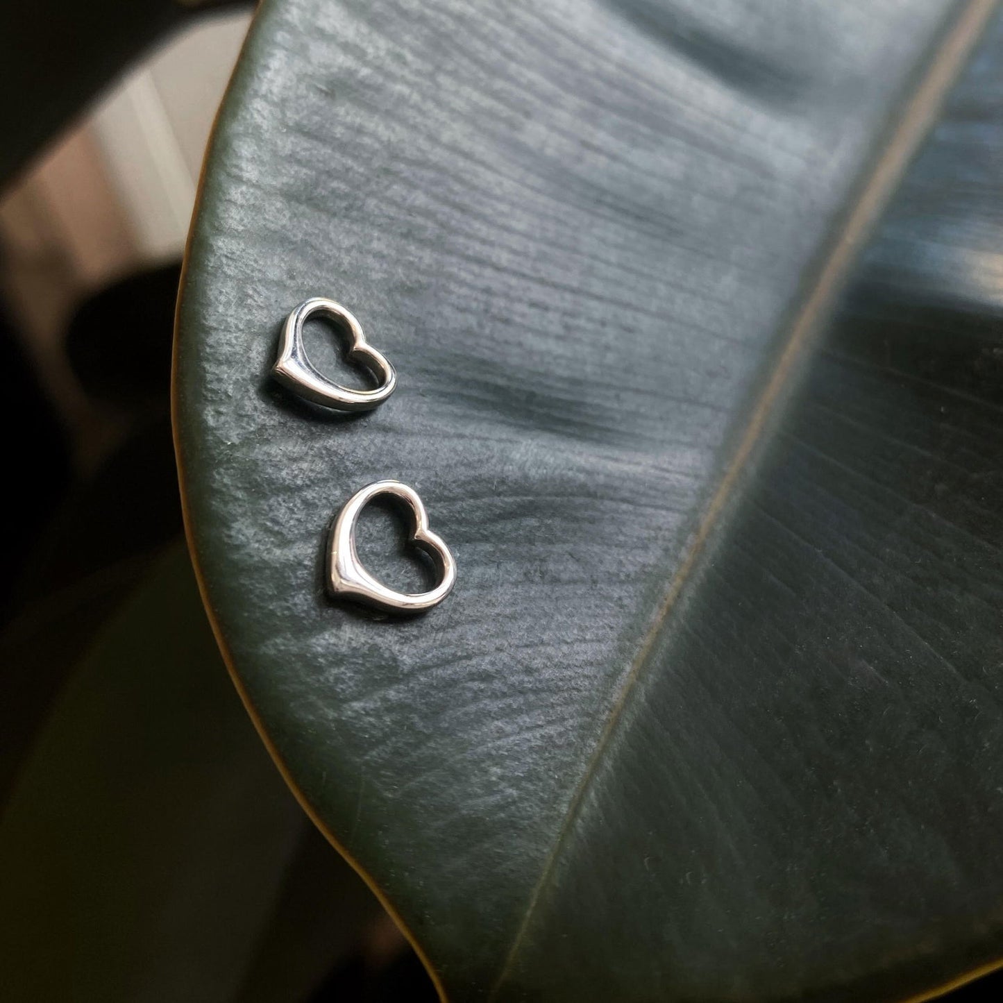 Photo of Petite Heart Studs in a decorative scene, designed by , available at Plumb Gold & Plumb Silver