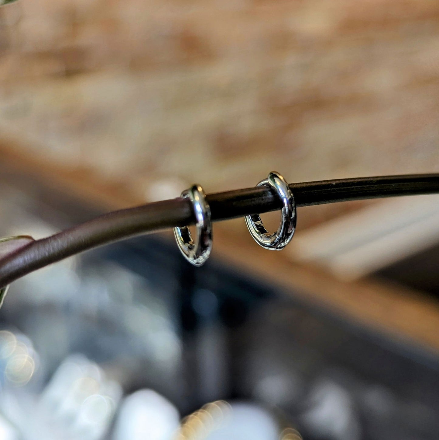 Photo of Petite Silver Hoops in a decorative scene, designed by , available at Plumb Gold & Plumb Silver
