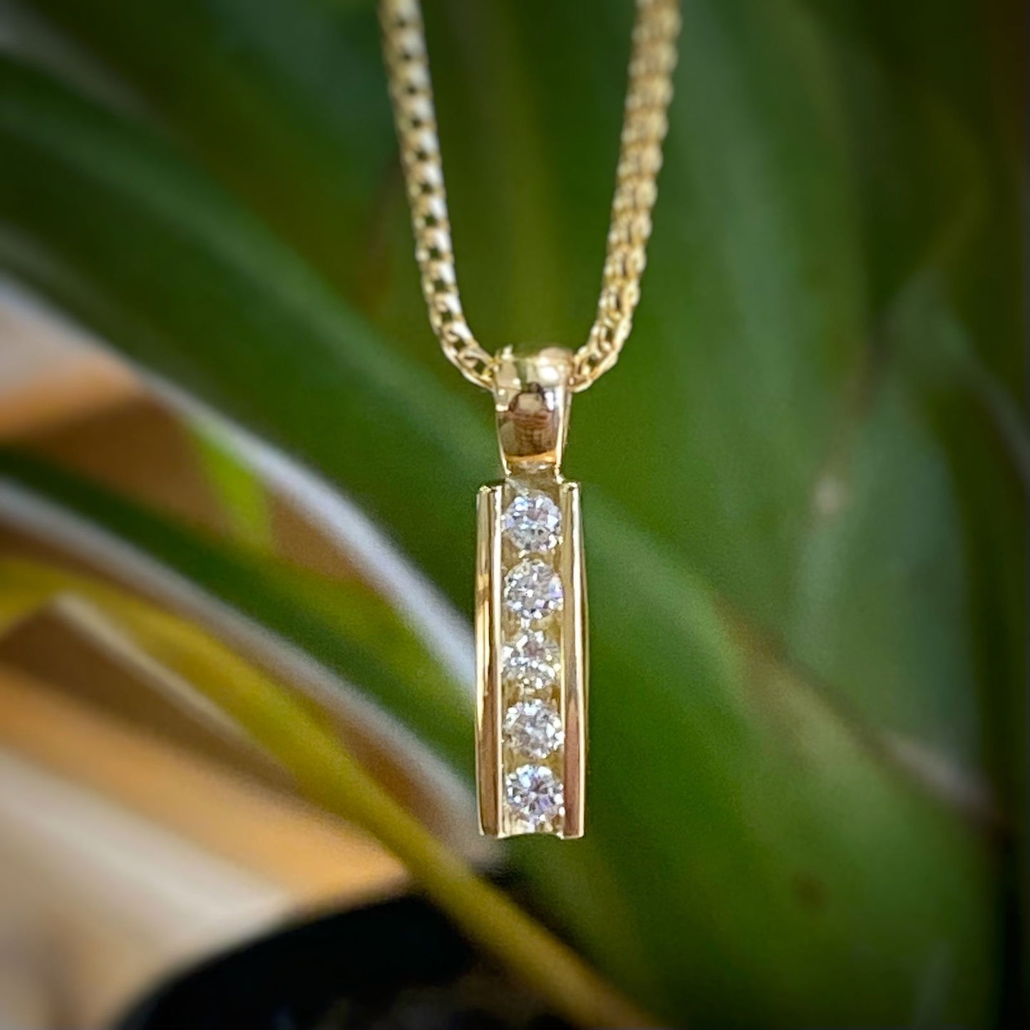 Photo of "Phoenix" Diamond Bar Pendant in a decorative scene, designed by -, available at Plumb Gold & Plumb Silver