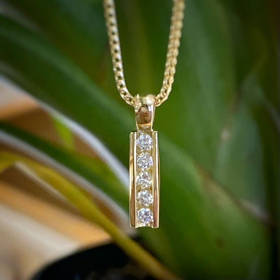 Photo of "Phoenix" Diamond Bar Pendant in a decorative scene, designed by -, available at Plumb Gold & Plumb Silver