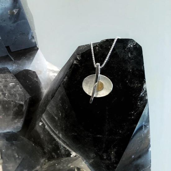 Photo of Pierced Oval Pendant in a decorative scene, designed by , available at Plumb Gold & Plumb Silver