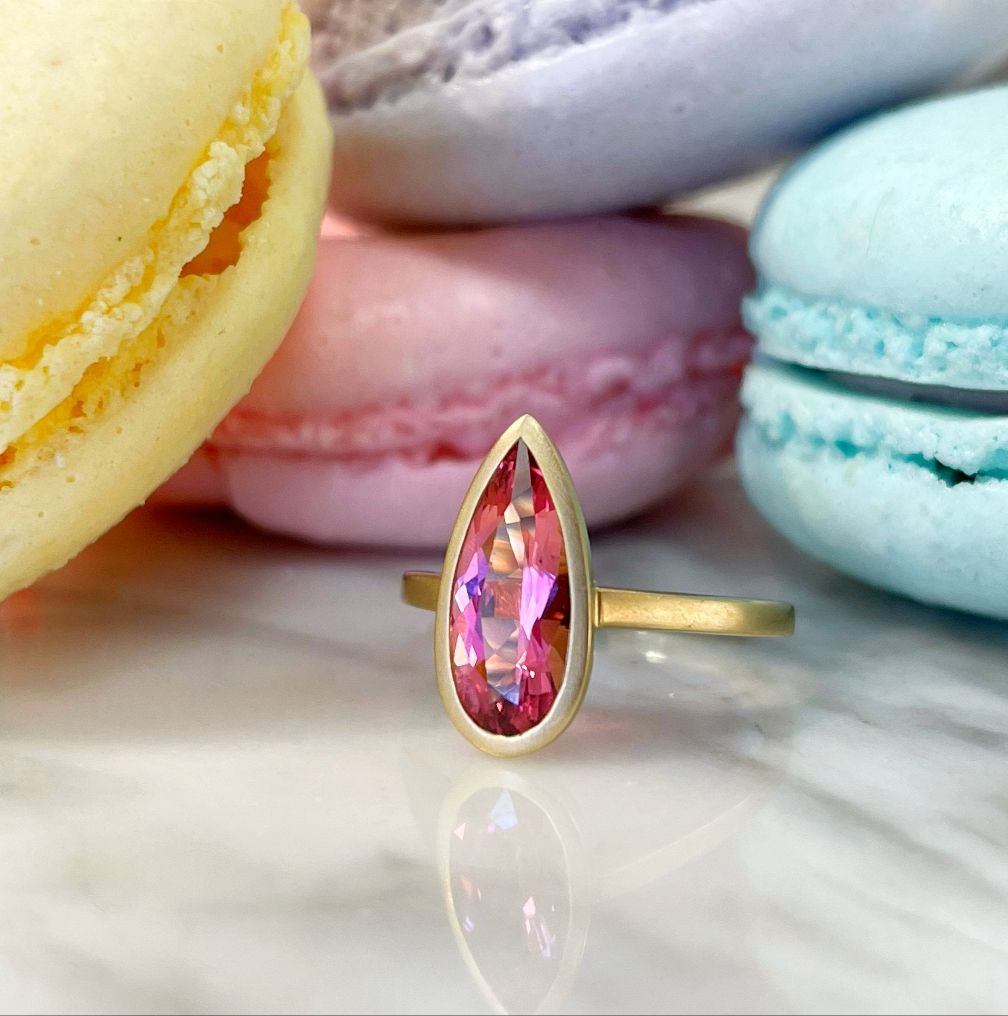 Photo of Pink Tourmaline Pear Ring in a decorative scene, designed by , available at Plumb Gold & Plumb Silver