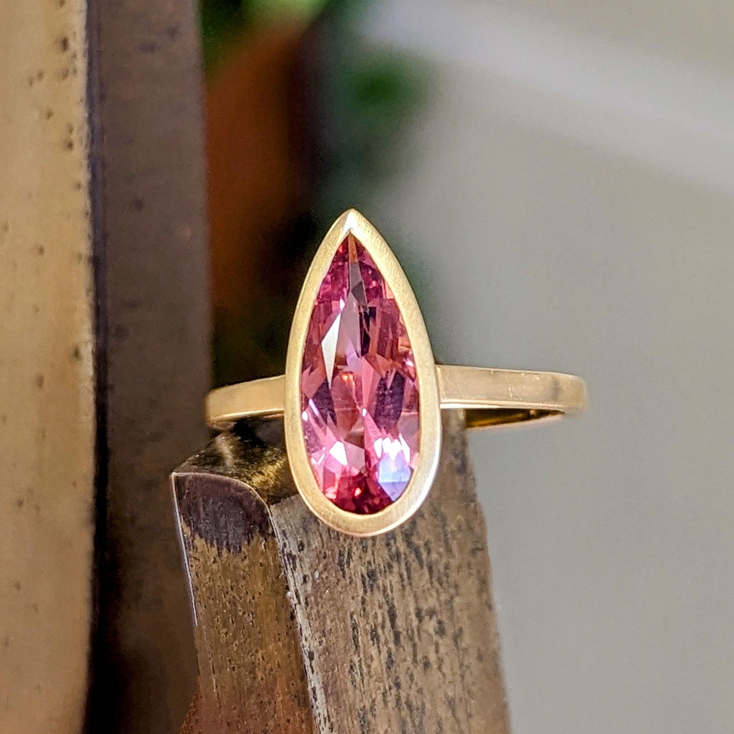 Photo of Pink Tourmaline Pear Ring in a decorative scene, designed by , available at Plumb Gold & Plumb Silver