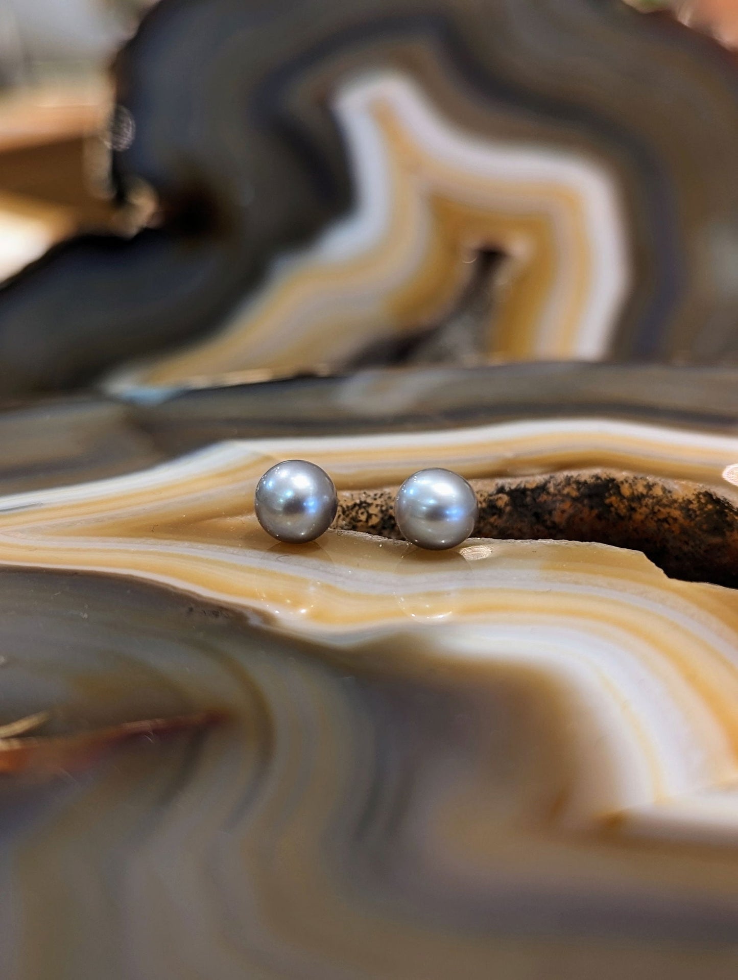 Photo of Plumb Silver Grey Pearl Stud Earrings in a decorative scene, designed by , available at Plumb Gold & Plumb Silver