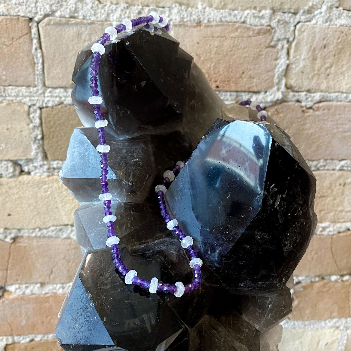 Photo of Plumb Silver Original Amethyst &amp; Moonstone Necklace in a decorative scene, designed by , available at Plumb Gold & Plumb Silver