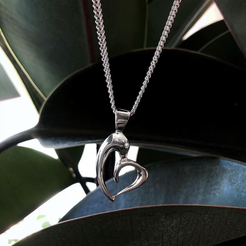 Photo of Plumb Silver Original Asymmetrical Heart Pendant in a decorative scene, designed by , available at Plumb Gold & Plumb Silver