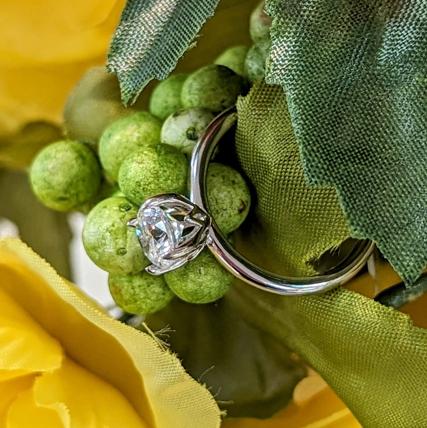 Photo of "Radha" Solitaire in a decorative scene, designed by , available at Plumb Gold & Plumb Silver