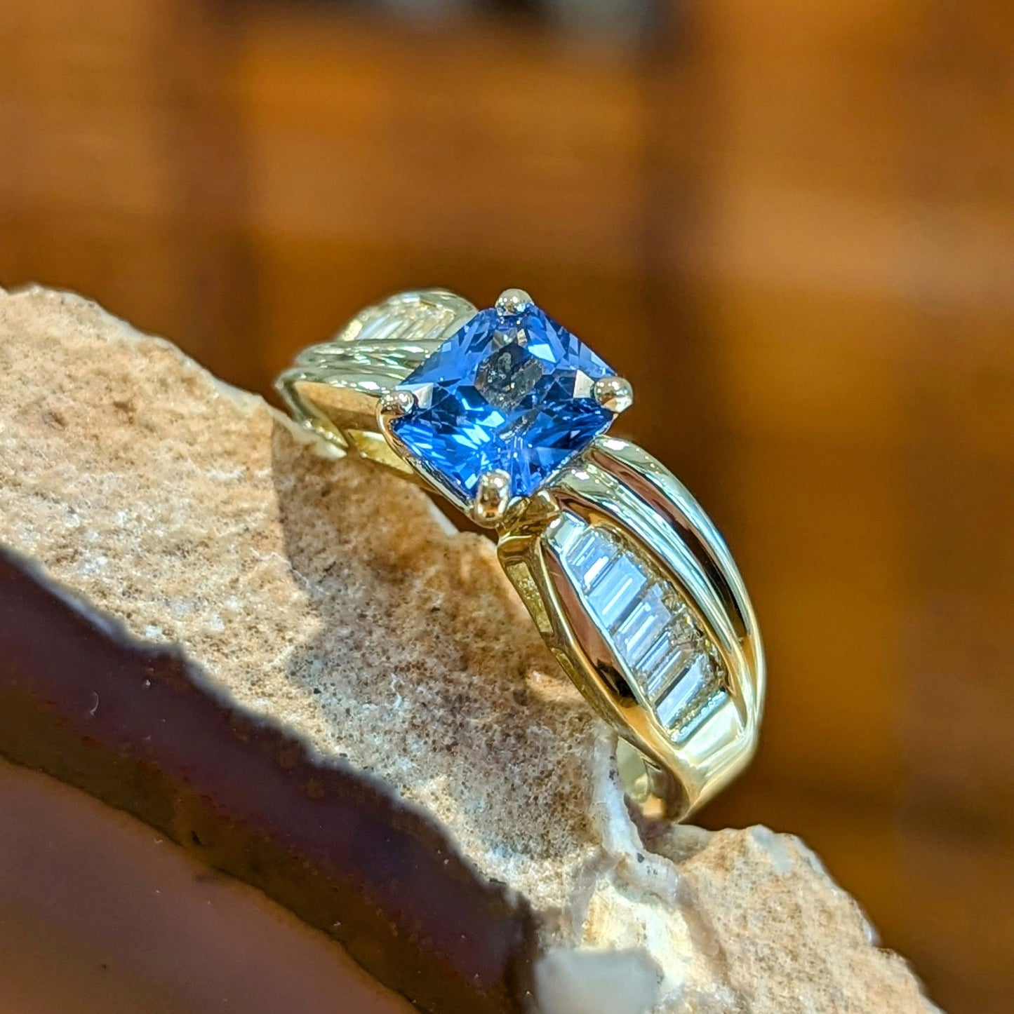 Photo of Radiant Sapphire and Baguette Ring in a decorative scene, designed by , available at Plumb Gold & Plumb Silver