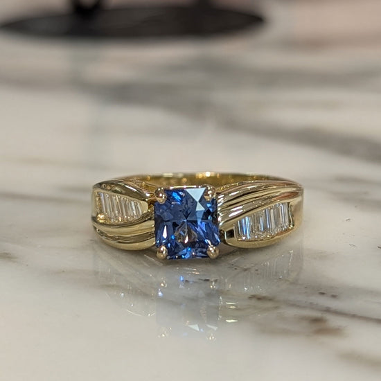Photo of Radiant Sapphire and Baguette Ring in a decorative scene, designed by , available at Plumb Gold & Plumb Silver