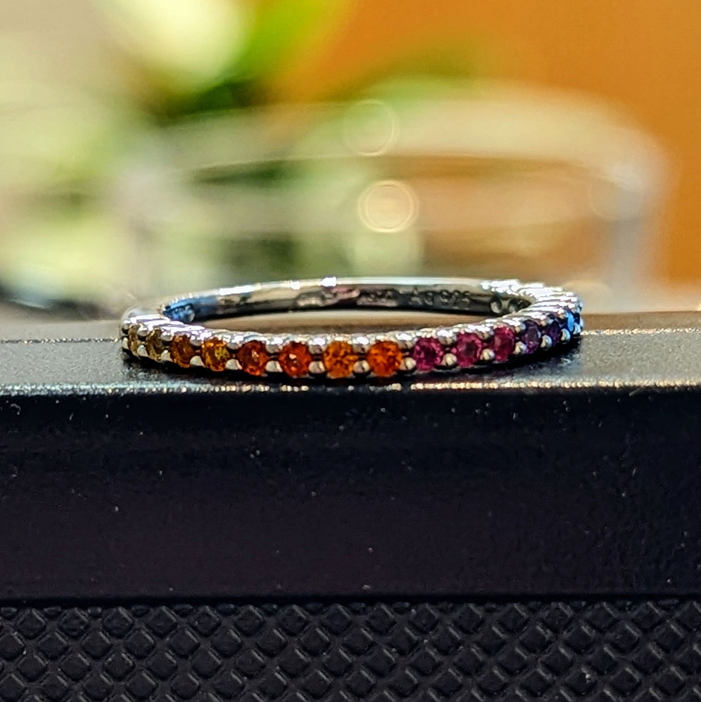 Photo of Rainbow CZ Ring in a decorative scene, designed by , available at Plumb Gold & Plumb Silver