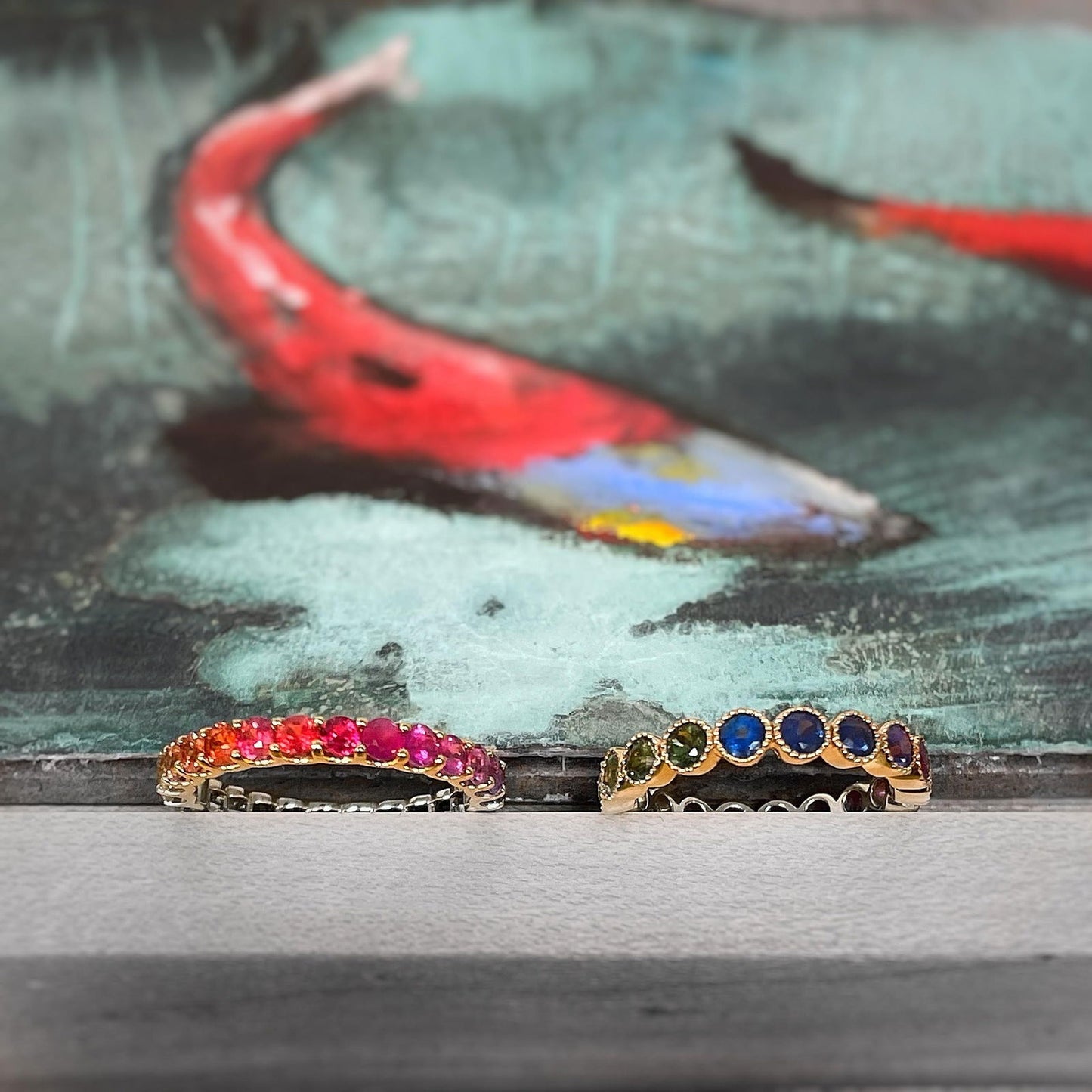 Photo of Rainbow Sapphire Eternity Band in a decorative scene, designed by , available at Plumb Gold & Plumb Silver
