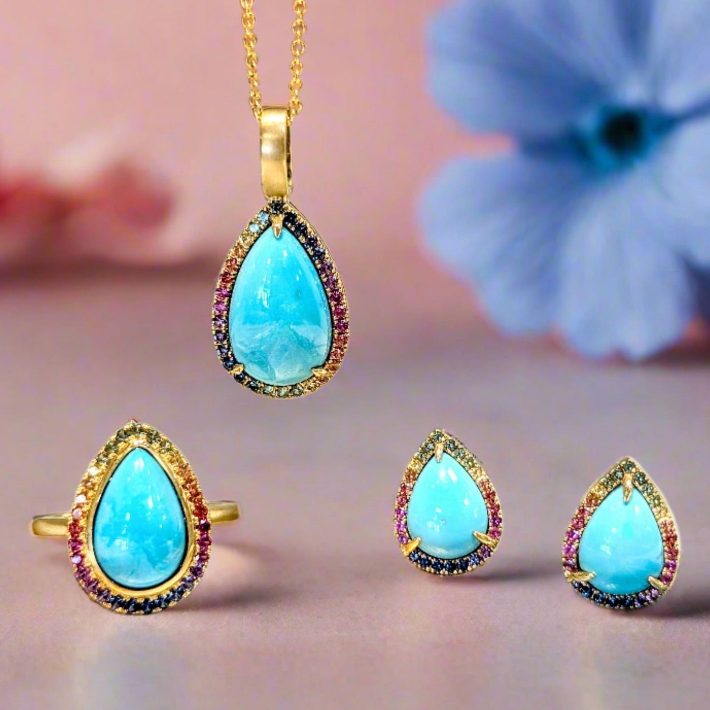 Photo of Rainbow Sapphire Halo Turquoise Pendant in a decorative scene, designed by , available at Plumb Gold & Plumb Silver