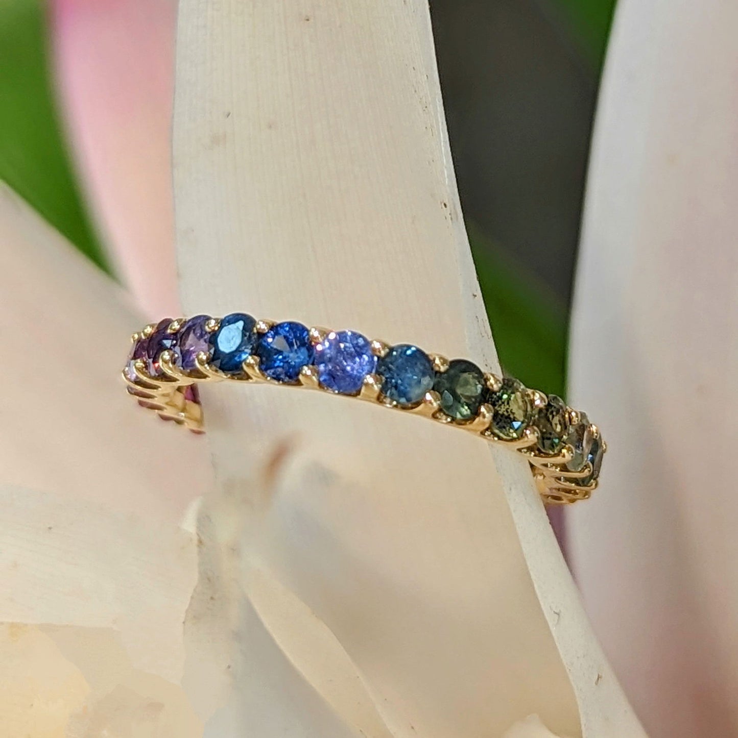 Photo of Rainbow Sapphire Ring in a decorative scene, designed by , available at Plumb Gold & Plumb Silver