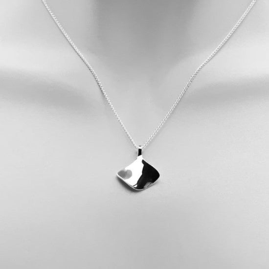 Photo of "Reflection" Necklace in a decorative scene, designed by , available at Plumb Gold & Plumb Silver