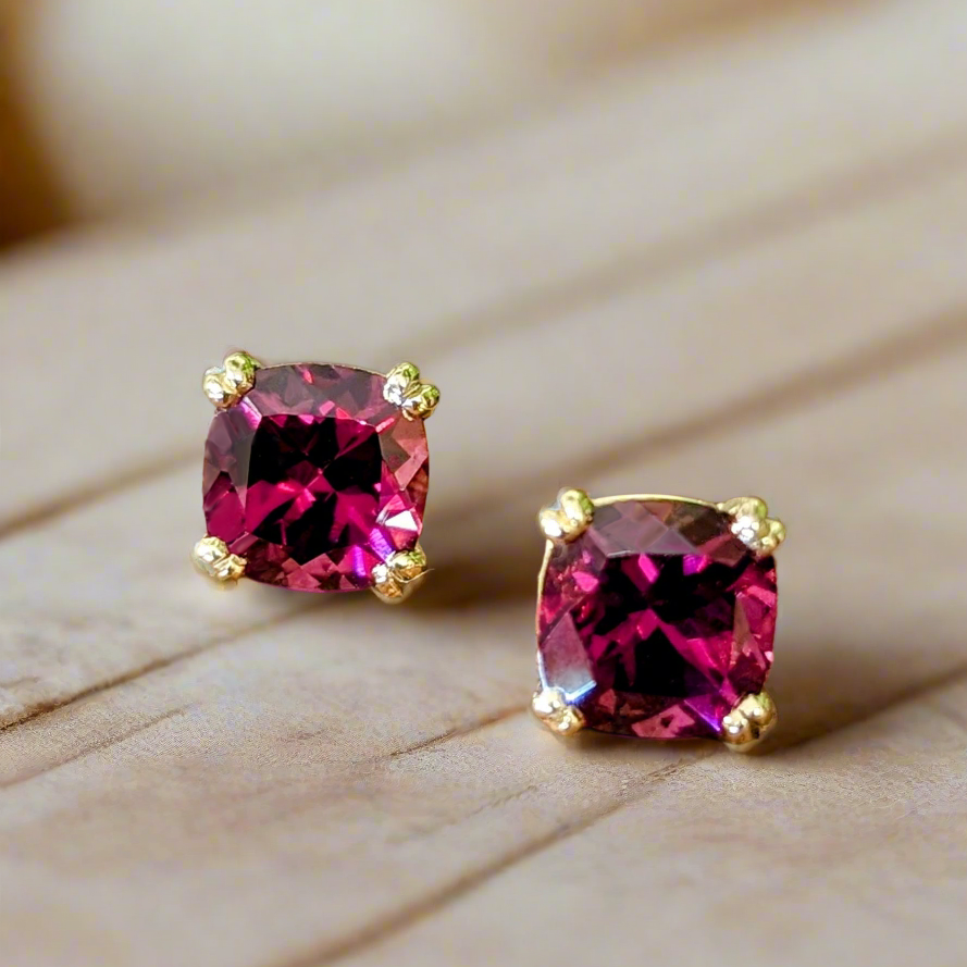 Photo of Rhodolite Garnet studs in a decorative scene, designed by -, available at Plumb Gold & Plumb Silver