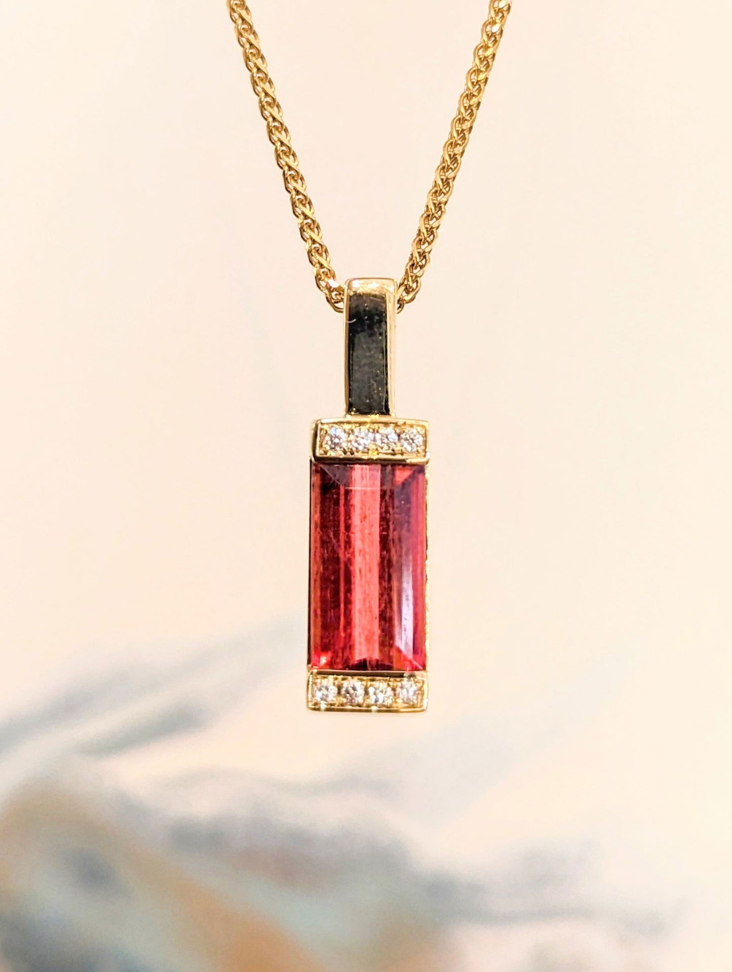 Photo of Rubellite Bar Pendant in a decorative scene, designed by , available at Plumb Gold & Plumb Silver