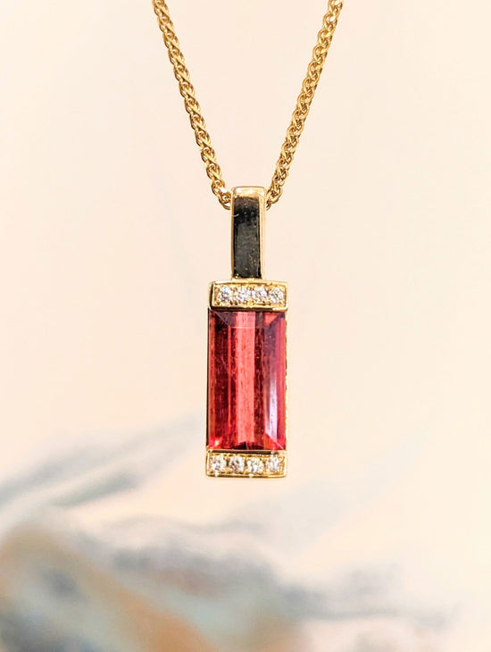 Photo of Rubellite Bar Pendant in a decorative scene, designed by , available at Plumb Gold & Plumb Silver