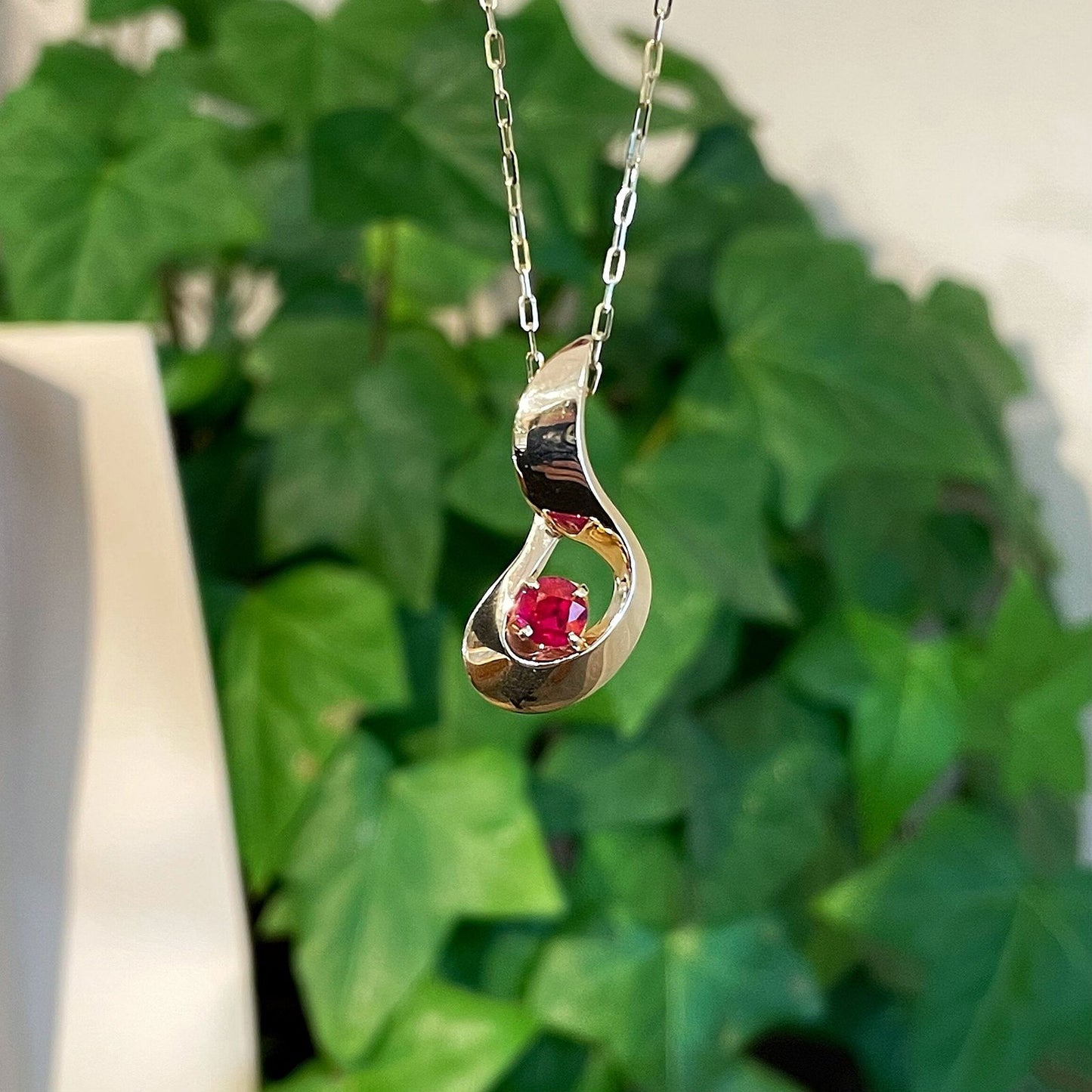 Photo of Ruby Pendant in a decorative scene, designed by , available at Plumb Gold & Plumb Silver