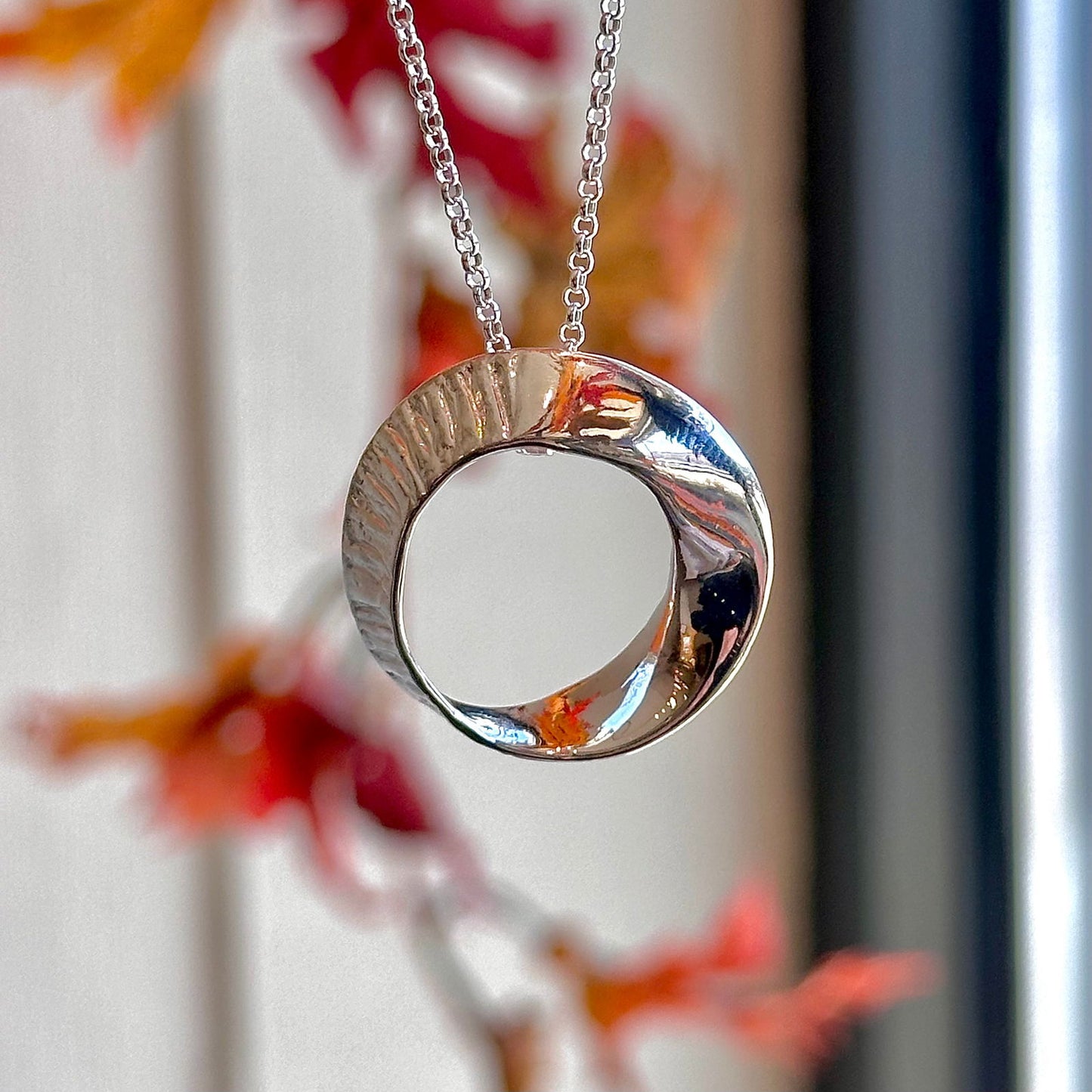 Photo of Seaweed Pendant in a decorative scene, designed by -, available at Plumb Gold & Plumb Silver