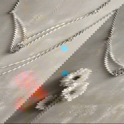 Photo of "Sensational Swing" Necklace in a decorative scene, designed by , available at Plumb Gold & Plumb Silver