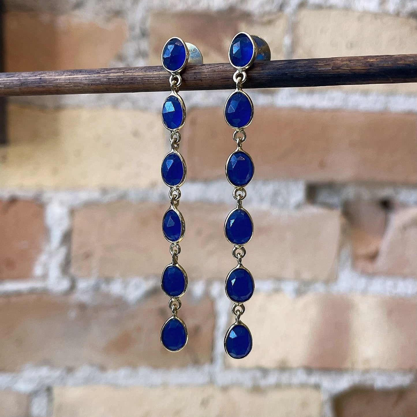 Photo of “Shade” Blue Jade Dangles in a decorative scene, designed by , available at Plumb Gold & Plumb Silver