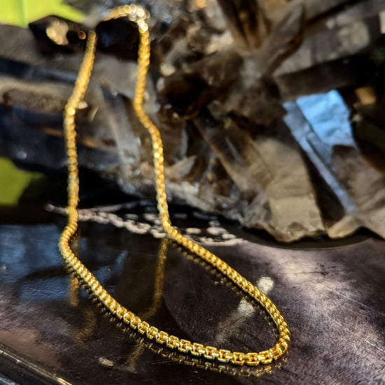 Photo of Silver or Gold Plated Box Chain in a decorative scene, designed by , available at Plumb Gold & Plumb Silver