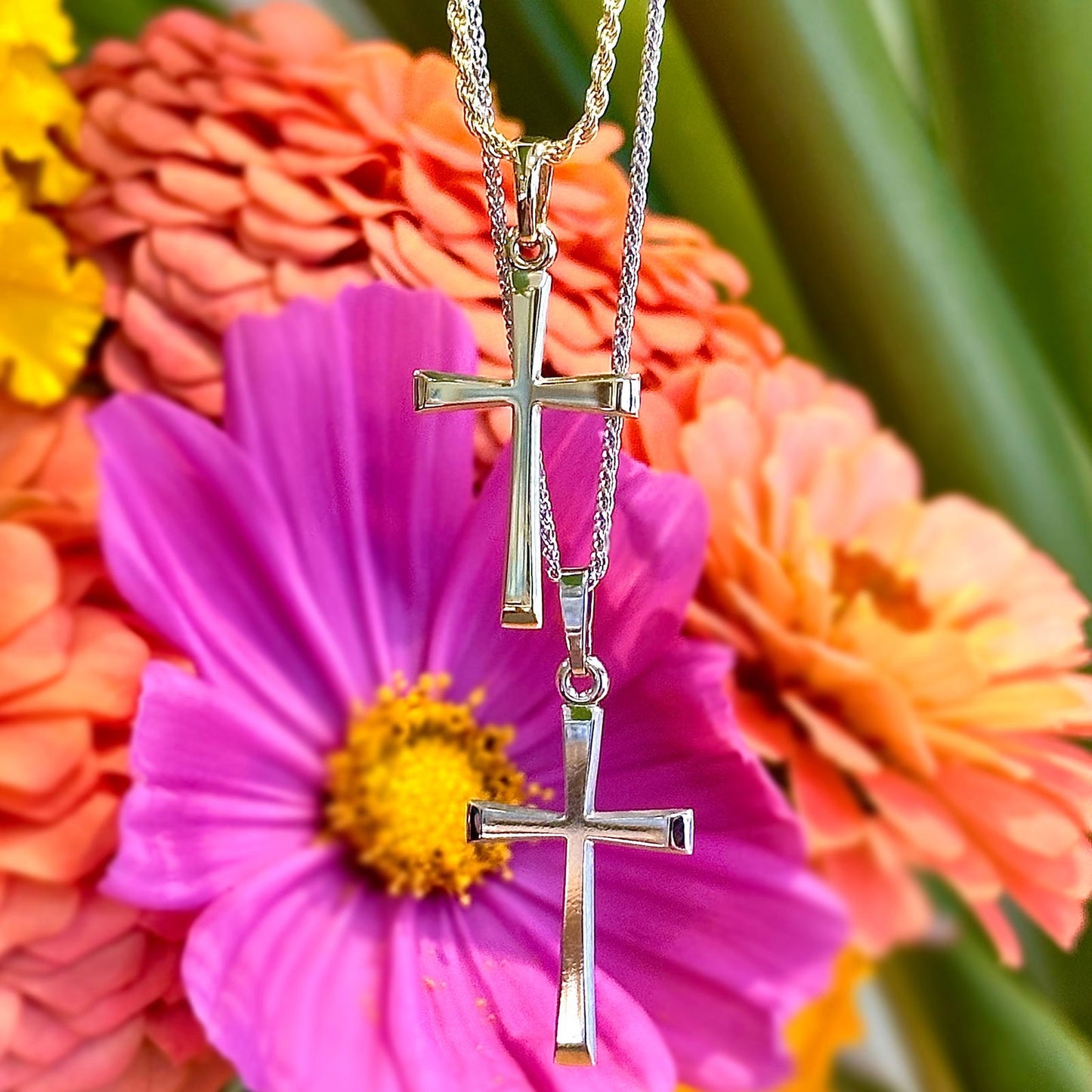 Photo of Simple Tapered Cross Pendant in a decorative scene, designed by , available at Plumb Gold & Plumb Silver