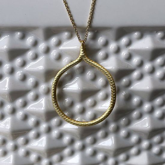 Photo of “Snakeskin” Pendant in a decorative scene, designed by , available at Plumb Gold & Plumb Silver
