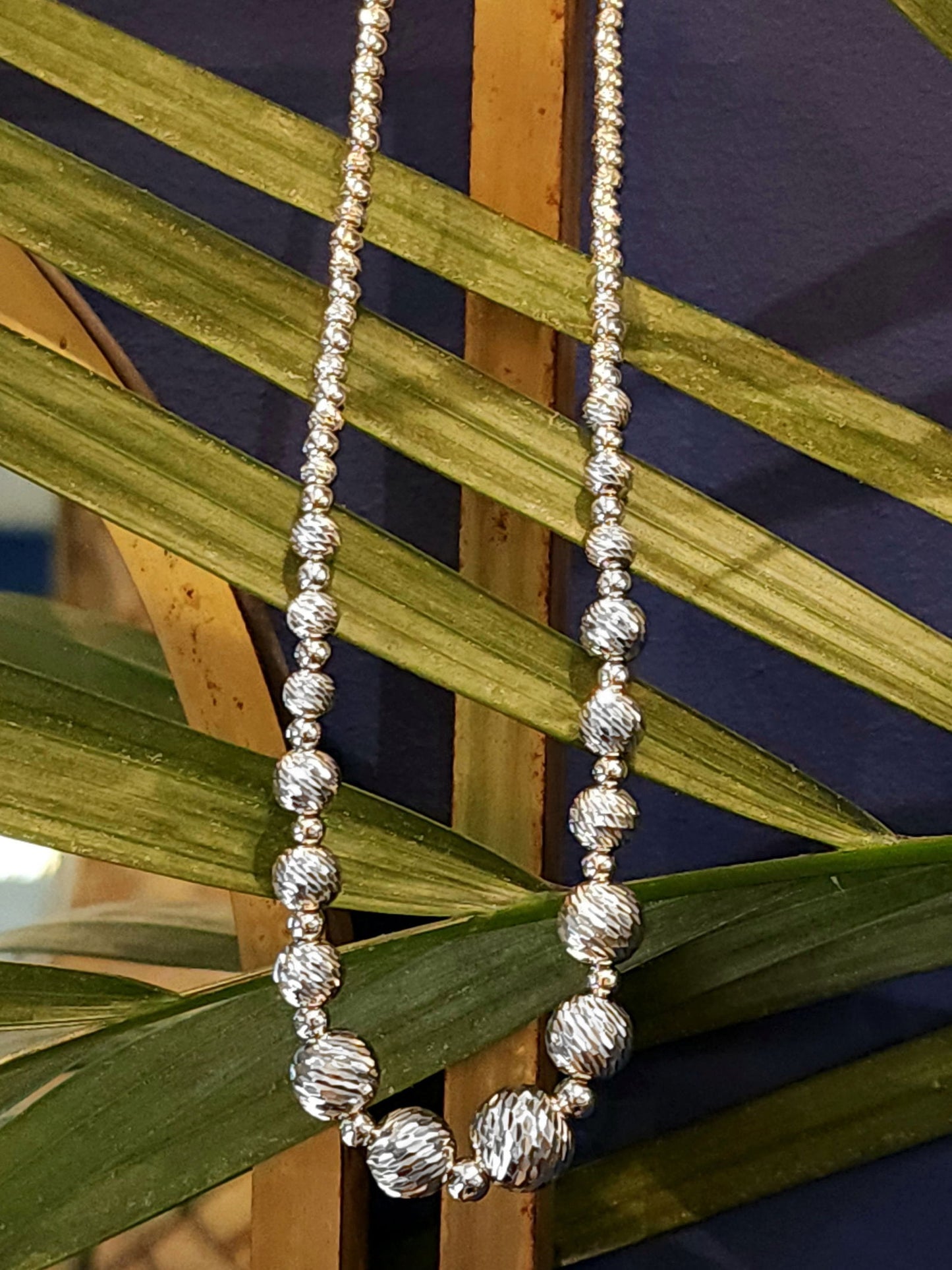 Photo of Sparkle Faceted Bead Necklace in a decorative scene, designed by , available at Plumb Gold & Plumb Silver
