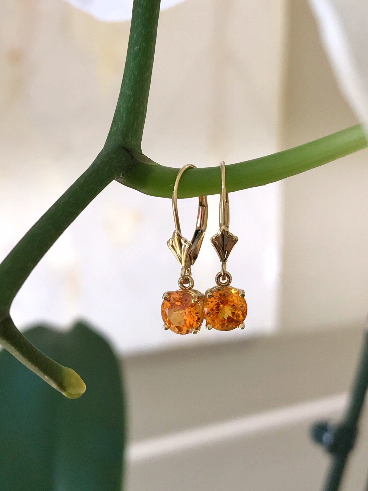 Photo of Spessartite Garnet Dangles in a decorative scene, designed by , available at Plumb Gold & Plumb Silver