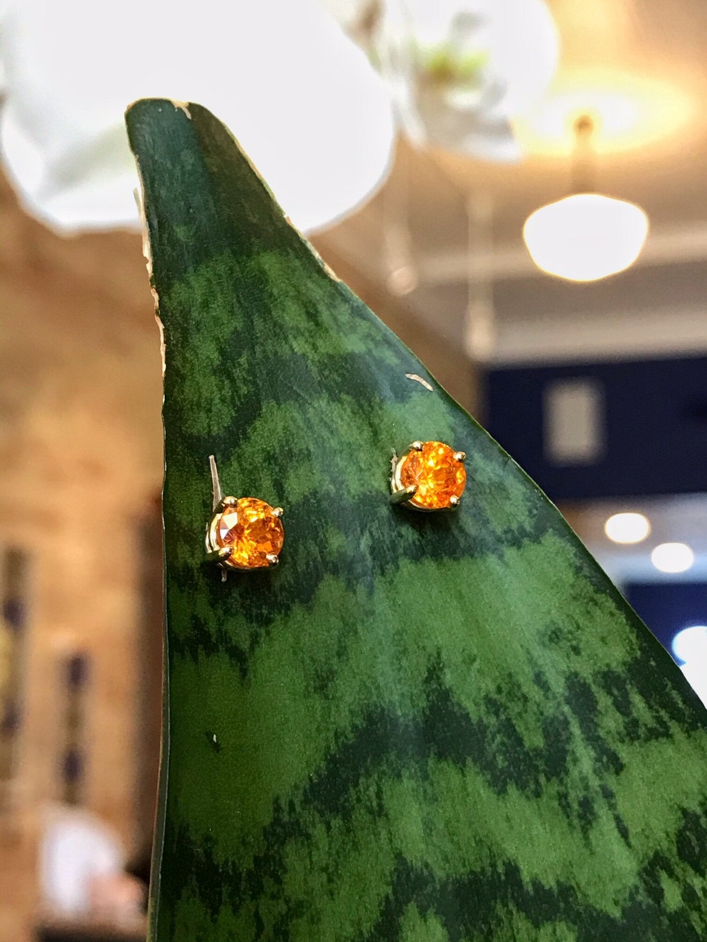 Photo of Spessartite Garnet Studs in a decorative scene, designed by , available at Plumb Gold & Plumb Silver