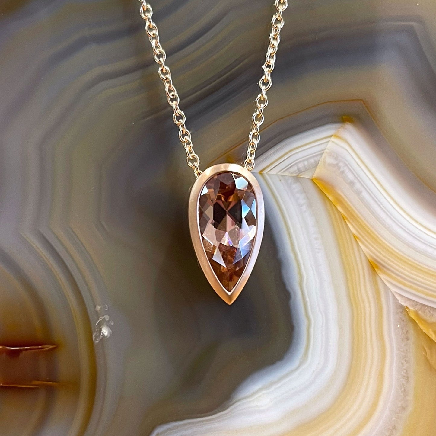 Photo of Spice Zircon Necklace in a decorative scene, designed by , available at Plumb Gold & Plumb Silver