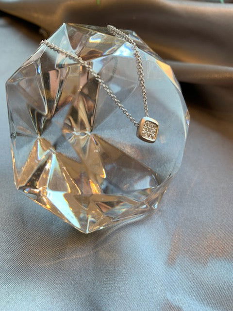 Photo of Square Frame Cluster necklace in a decorative scene, designed by , available at Plumb Gold & Plumb Silver