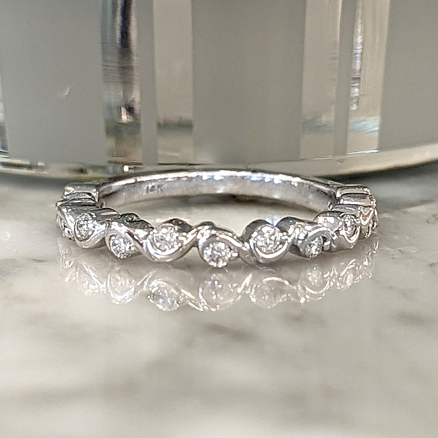 Photo of Squiggle Diamond Band in a decorative scene, designed by , available at Plumb Gold & Plumb Silver