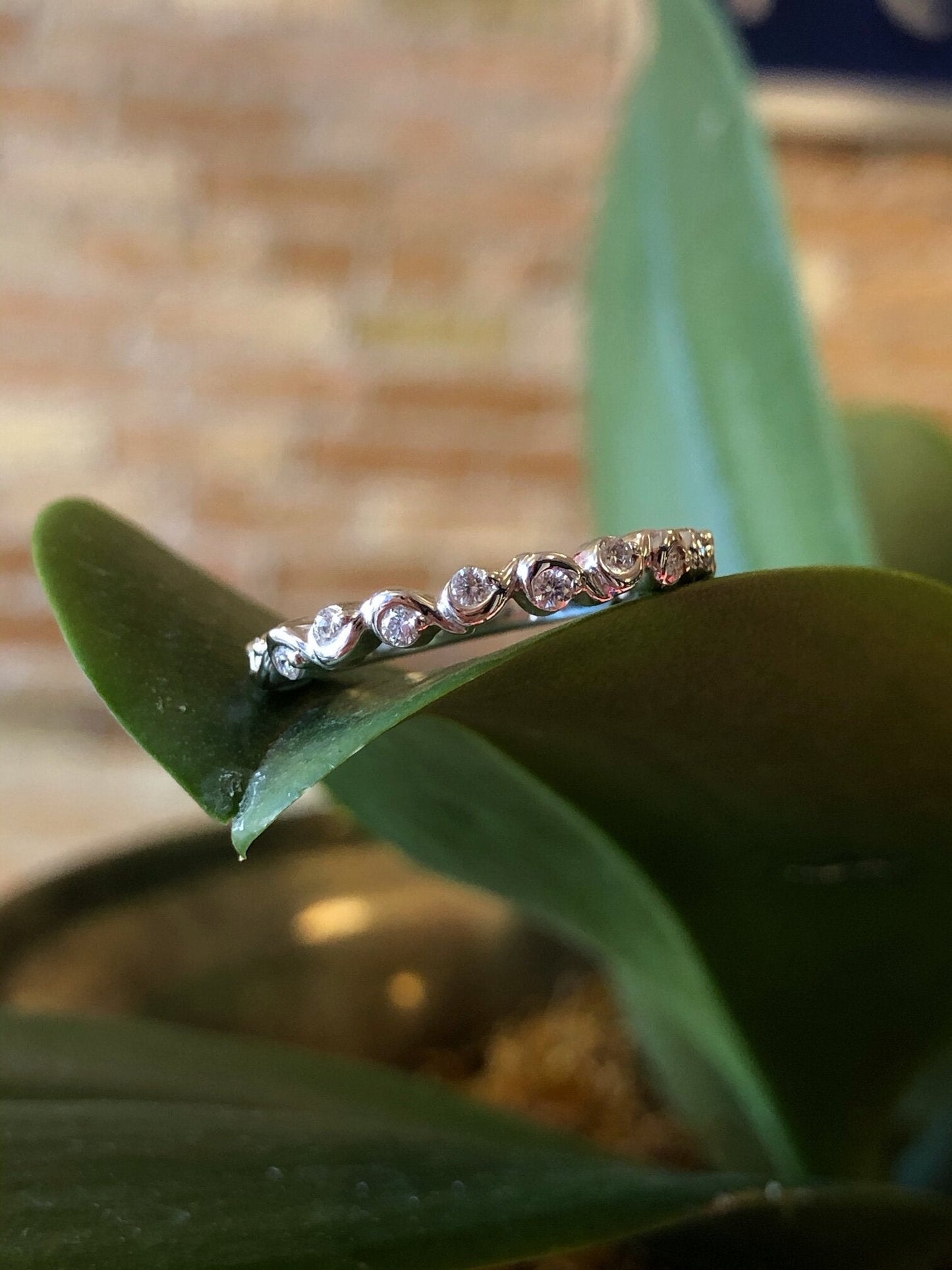Photo of Squiggle Diamond Band in a decorative scene, designed by , available at Plumb Gold & Plumb Silver