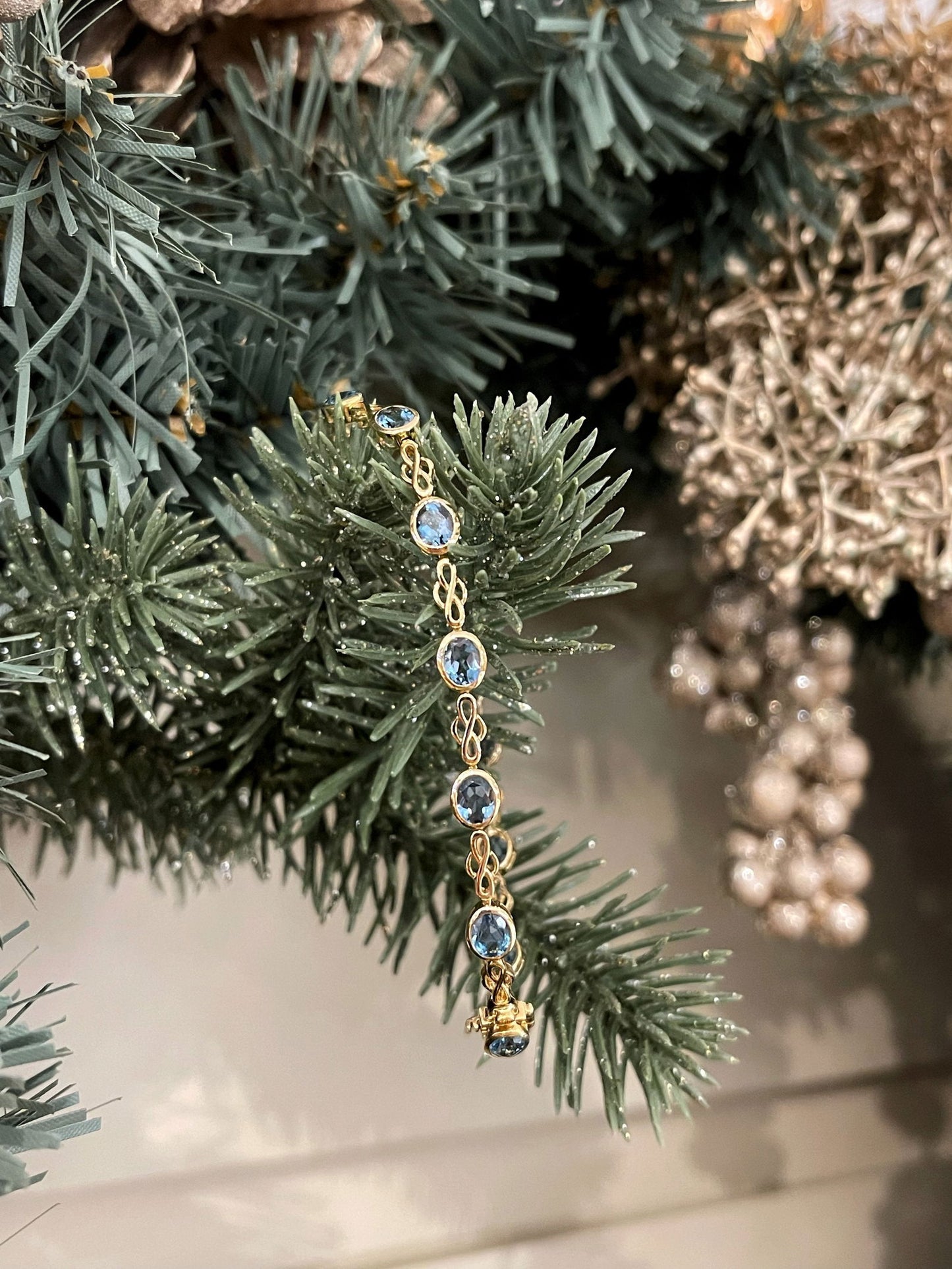 Photo of Stanton Color London Blue Topaz Bracelet in a decorative scene, designed by , available at Plumb Gold & Plumb Silver