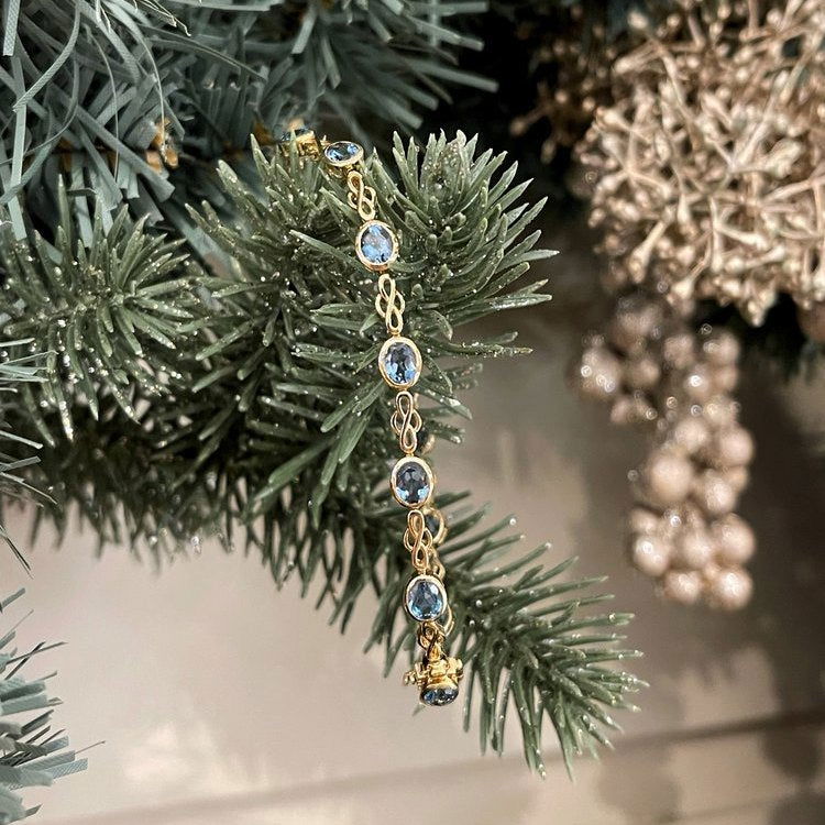 Photo of Stanton Color London Blue Topaz Bracelet in a decorative scene, designed by , available at Plumb Gold & Plumb Silver