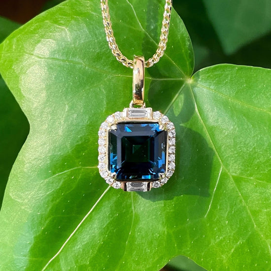 Photo of Stanton Color London Blue Topaz Pendant in a decorative scene, designed by , available at Plumb Gold & Plumb Silver